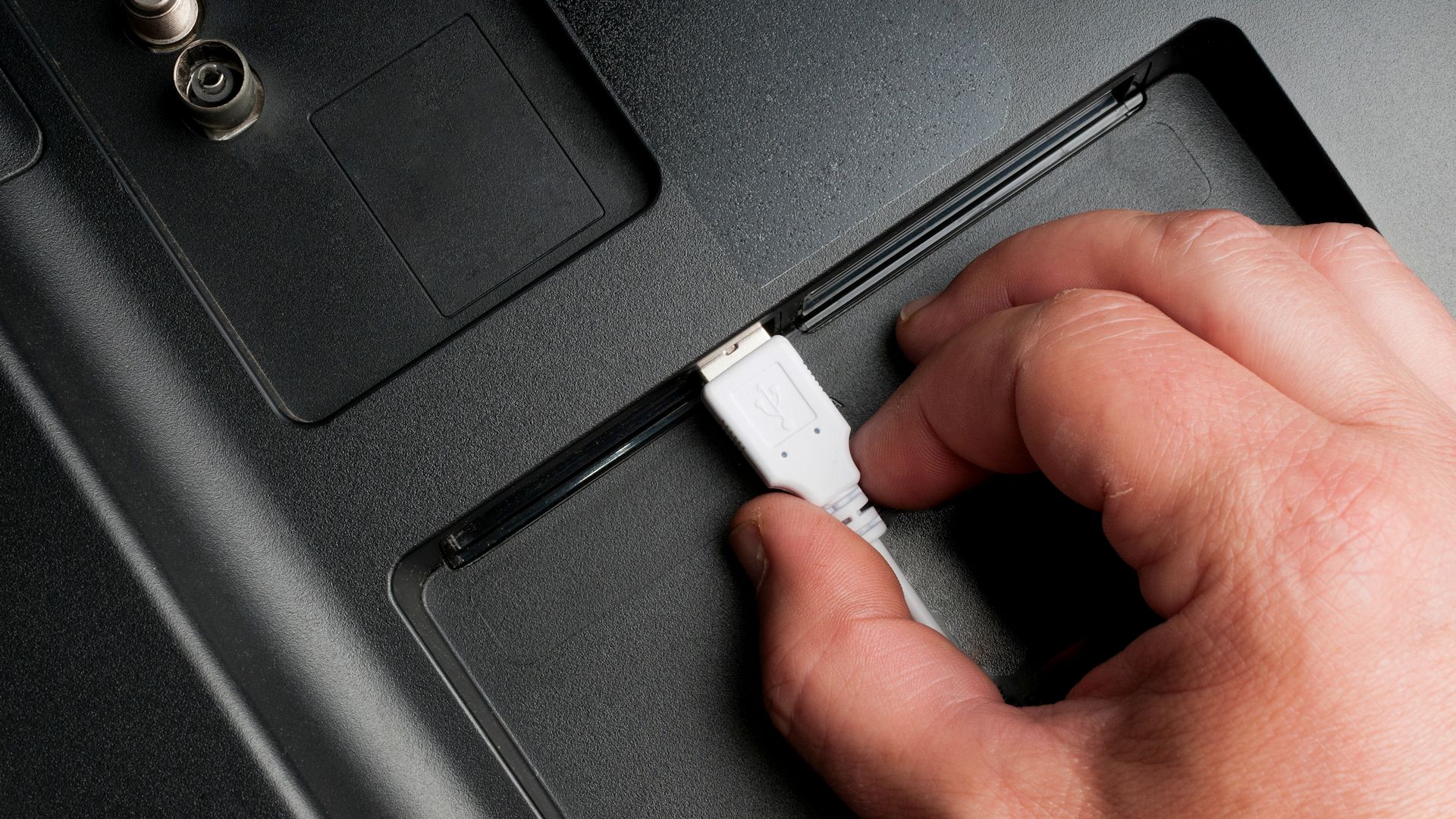 Чоловік підключив USB тип кабелю в телевізорі задні порти