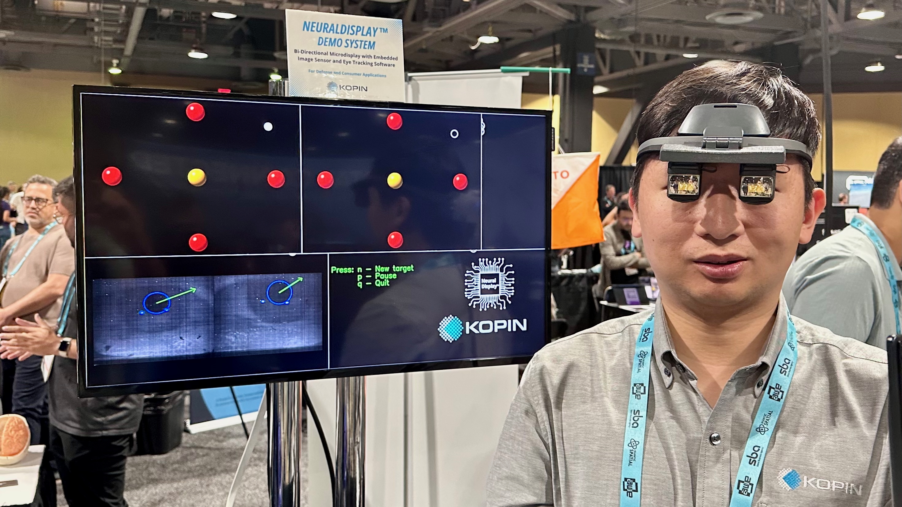 Фото інженера, що носить прототип Kopin NeuralDisplay OLED перед дисплеєм, що показує його відстеження очей у дії