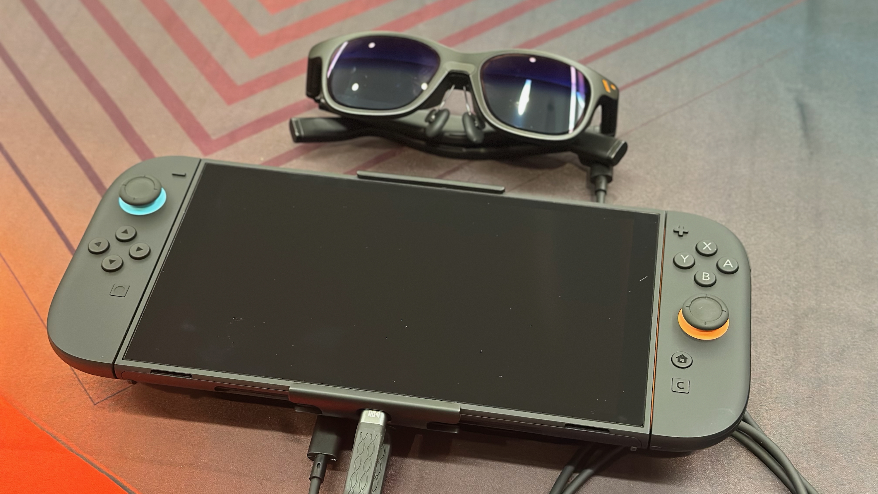 Перемикач Nintendo 2 сидить на столі з окулями Viters Pro XR, що сидять над ним.