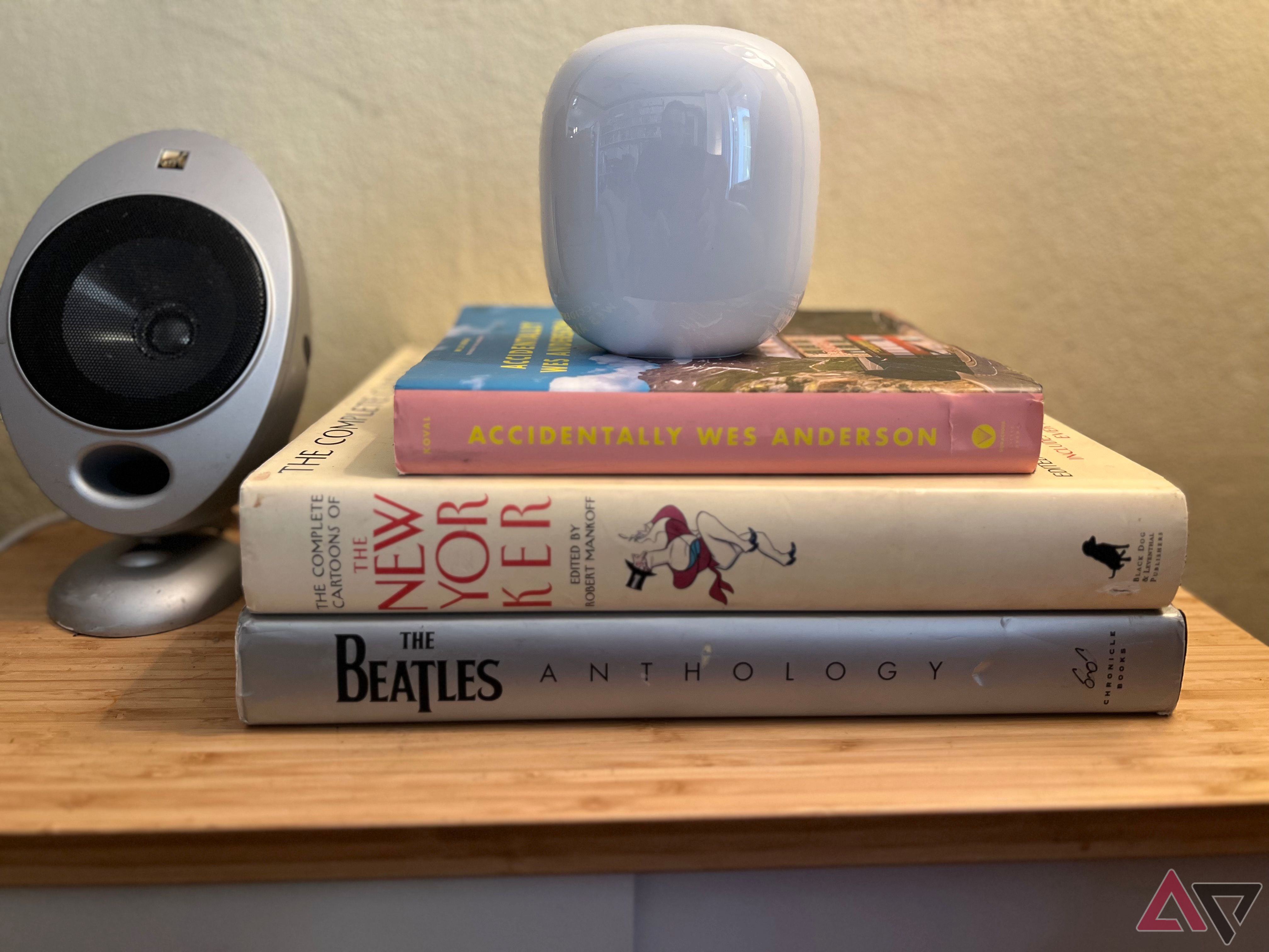Google Nest Wi -Fi Pro на стеку книг на бічному столі