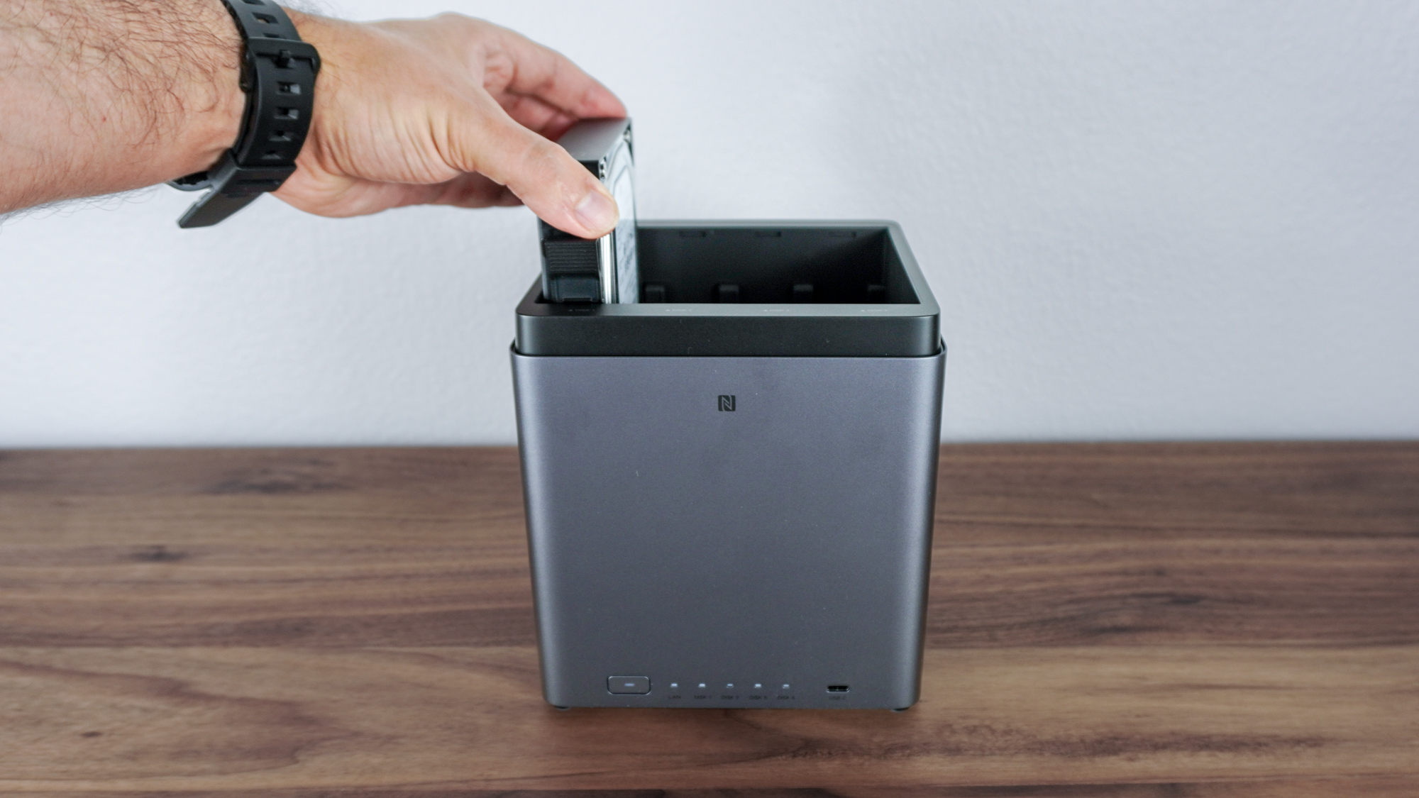 Людина, яка вставляє жорсткий диск у Ugreen NASync DH4300 Plus