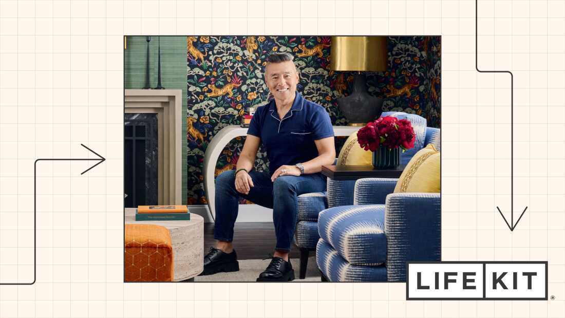 Екологічний портрет Верна Іпа, який сидить на синьо-білому дивані з візерунками, естетично привабливу вітальню, яку він прикрасив шпалерами з тигром і квітковим візерунком позаду нього.